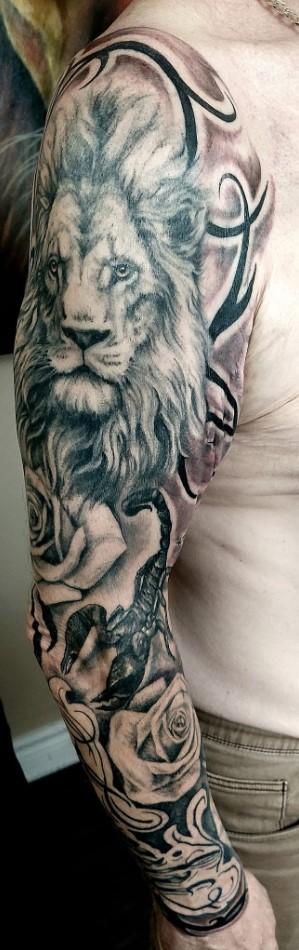 Tatouage réaliste d'un lion accompagné de roses et d'un scorpion